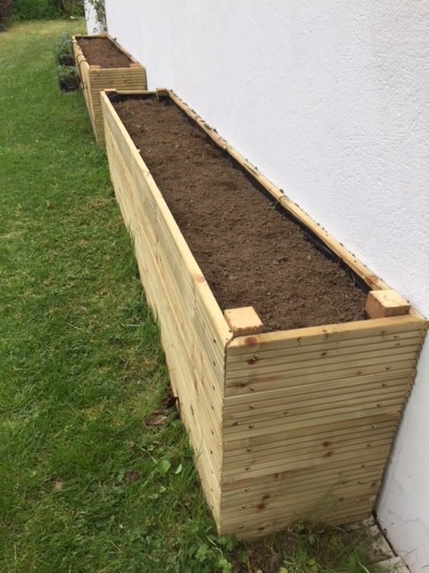 big wooden boxes filled with soil